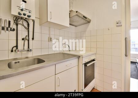 Intérieur de la petite cuisine avec armoires et appareils dans l'appartement avec des murs blancs Banque D'Images