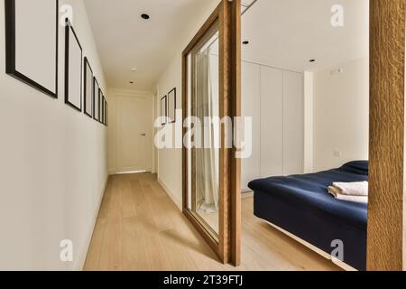 Confortable lit bleu et armoire dans une chambre spacieuse vue par la porte dans un appartement contemporain avec passage vide Banque D'Images