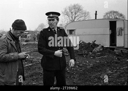Policier et un entrepreneur en démolition sur une friche à côté d'une caravane de voyageurs pendant le nettoyage des bidonvilles et la démolition de St ann's, Nottingham. 1969-72 Banque D'Images