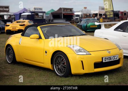 Vue de trois quarts de face d'un cabriolet jaune de 2006 Nissan Fairlady 350Z exposé au salon britannique de l'automobile de Farnborough en 2023 Banque D'Images