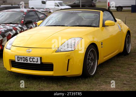 Vue de trois quarts de face d'un cabriolet jaune de 2006 Nissan Fairlady 350Z exposé au salon britannique de l'automobile de Farnborough en 2023 Banque D'Images