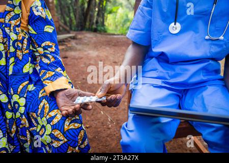 Un médecin donne des médicaments à un patient âgé tout en expliquant la prescription du comprimé. Banque D'Images