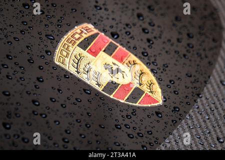 Logo Porsche sur une voiture noire avec des gouttelettes d'eau. Ferdinand Porsche a fondé la société en 1931 avec des bureaux principaux dans le centre de Stuttgart. Banque D'Images