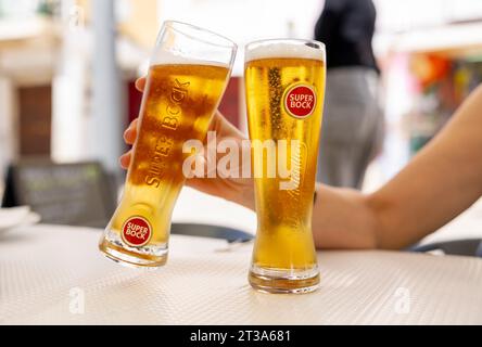 Lisboa, Portugal - 19.09.2023 Femme tient un verre de bière portugaise de la marque 'Super Book' pour encourager, dans une terrasse d'un restaurant à Lisbonne Banque D'Images