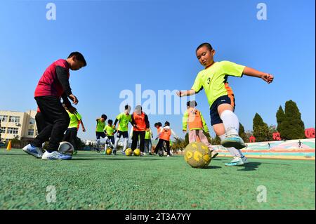 QINGDAO, CHINE - 24 OCTOBRE 2023 - des élèves du primaire s'entraînent sur un terrain de football à Qingdao, dans la province du Shandong, en Chine, le 24 octobre 2023. Banque D'Images