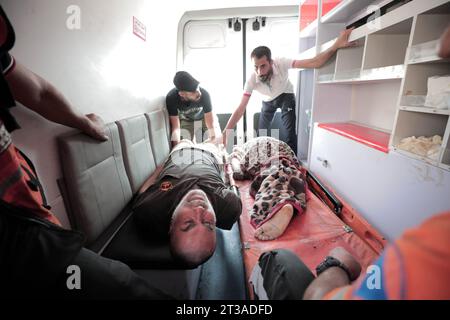 24 octobre 2023 : Gaza, Palestine. 24 Ottobre 2023. Des Palestiniens blessés lors d'un bombardement israélien meurtrier dans le camp d'al Nuiserat sont chargés dans une ambulance qui se dirige vers l'hôpital de Deir Al Balah les dernières frappes contre un marché animé du camp de réfugiés palestiniens d'Al Nuiserat ont fait plusieurs victimes et détruit la région (Credit image : © Adel Al Hwajre/IMAGESLIVE via ZUMA Press Wire) À USAGE ÉDITORIAL UNIQUEMENT ! Non destiné à UN USAGE commercial ! Banque D'Images