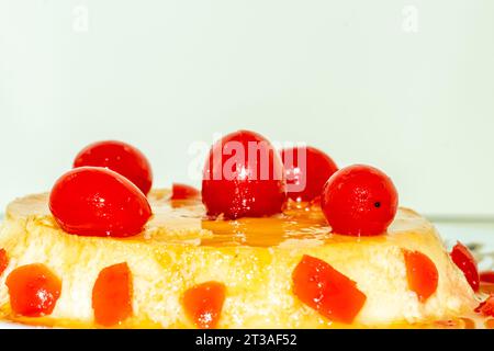 Un pudding merveilleusement aromatisé à base de lait d'oeuf et de sucre et servi nappé de fruits de cerise rouge Banque D'Images