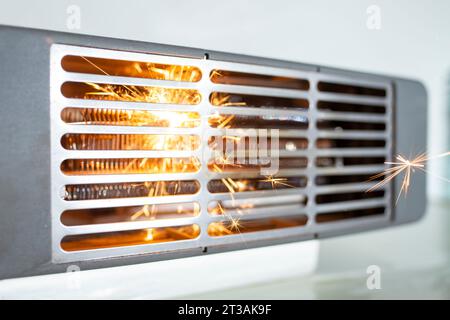 Radiateur soufflant électrique avec des étincelles, concept créatif de court-circuit domestique Banque D'Images