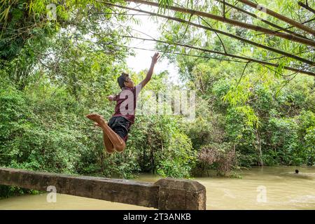 Cambodge, Kampong Phluk, les enfants plongent dans la rivière gonflée Banque D'Images