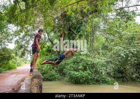 Cambodge, Kampong Phluk, les enfants plongent dans la rivière gonflée Banque D'Images