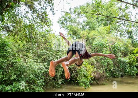 Cambodge, Kampong Phluk, les enfants plongent dans la rivière gonflée Banque D'Images