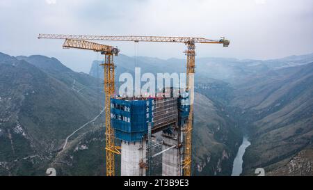 Guanling. 24 octobre 2023. Cette photo aérienne prise le 24 octobre 2023 montre une tour principale du pont du Grand canyon de Huajiang dans la province du Guizhou, dans le sud-ouest de la Chine. La dernière tour principale du pont du grand canyon Huajiang a été achevée mardi dans la province du Guizhou, dans le sud-ouest de la Chine, marquant une étape importante dans la construction du pont le plus haut du monde. Avec une hauteur conçue de 625 mètres entre le pont et la rivière Beipanjiang ci-dessous, le pont du grand canyon Huajiang devrait être le plus haut du monde après son achèvement en 2025. Crédit : Tao Liang/Xinhua/Alamy Live News Banque D'Images