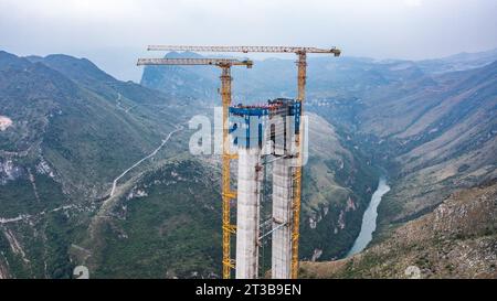 Guanling. 24 octobre 2023. Cette photo aérienne prise le 24 octobre 2023 montre une tour principale du pont du Grand canyon de Huajiang dans la province du Guizhou, dans le sud-ouest de la Chine. La dernière tour principale du pont du grand canyon Huajiang a été achevée mardi dans la province du Guizhou, dans le sud-ouest de la Chine, marquant une étape importante dans la construction du pont le plus haut du monde. Avec une hauteur conçue de 625 mètres entre le pont et la rivière Beipanjiang ci-dessous, le pont du grand canyon Huajiang devrait être le plus haut du monde après son achèvement en 2025. Crédit : Tao Liang/Xinhua/Alamy Live News Banque D'Images