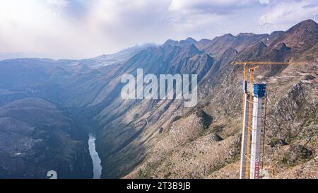 Guanling. 24 octobre 2023. Cette photo aérienne prise le 24 octobre 2023 montre une tour principale du pont du Grand canyon de Huajiang dans la province du Guizhou, dans le sud-ouest de la Chine. La dernière tour principale du pont du grand canyon Huajiang a été achevée mardi dans la province du Guizhou, dans le sud-ouest de la Chine, marquant une étape importante dans la construction du pont le plus haut du monde. Avec une hauteur conçue de 625 mètres entre le pont et la rivière Beipanjiang ci-dessous, le pont du grand canyon Huajiang devrait être le plus haut du monde après son achèvement en 2025. Crédit : Tao Liang/Xinhua/Alamy Live News Banque D'Images