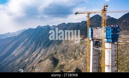 Guanling. 24 octobre 2023. Cette photo aérienne prise le 24 octobre 2023 montre une tour principale du pont du Grand canyon de Huajiang dans la province du Guizhou, dans le sud-ouest de la Chine. La dernière tour principale du pont du grand canyon Huajiang a été achevée mardi dans la province du Guizhou, dans le sud-ouest de la Chine, marquant une étape importante dans la construction du pont le plus haut du monde. Avec une hauteur conçue de 625 mètres entre le pont et la rivière Beipanjiang ci-dessous, le pont du grand canyon Huajiang devrait être le plus haut du monde après son achèvement en 2025. Crédit : Tao Liang/Xinhua/Alamy Live News Banque D'Images