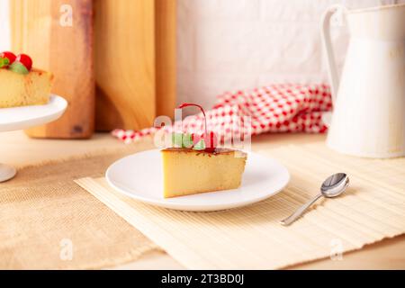 Tranche de dessert de flan maison, également connu sous le nom de crème caramel, pudding au caramel ou crème anglaise aux œufs, décoré de feuilles de menthe et de cerises, servi sur Banque D'Images