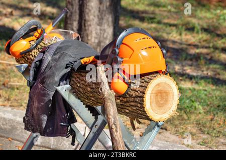 Sécurité standard, casque de sécurité et combinaison Stihl bûcheron dans le contexte d'une bûche par une journée ensoleillée. 09.26.23. Kiev. Ukraine. Banque D'Images