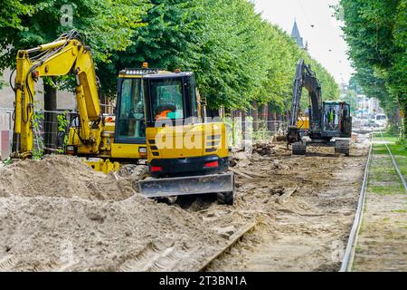 Vue de reconstruction de rue avec plusieurs excavatrices et autres machines, surface de rue démantelée, rails de tramway remplaçant les travaux Banque D'Images