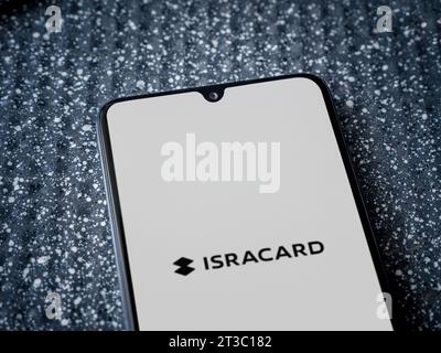 LOD, Israël - 16 juillet 2023 : écran de lancement de l'application Isracard sur smartphone sur fond métallique. Gros plan vue de dessus à plat. Banque D'Images