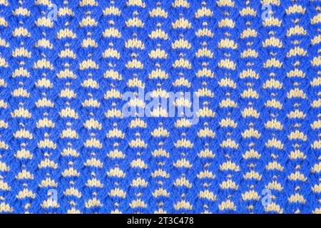 Fond abstrait bleu et jaune tricoté. Grand tissu tricoté avec un motif. Gros plan d'une couverture tricotée. Espace de copie Banque D'Images