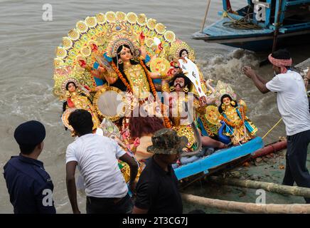 Les travailleurs de la Guwahati Municipal Corporation (GMC) plongent une idole de Durga dans la rivière Brahmapoutre à la fin du festival Durga Puja ou Dashami, le 24 octobre 2023 à Guwahati, Assam, en Inde. Durga Puja est l'un des festivals les plus importants en Inde. Crédit : David Talukdar/Alamy Live News Banque D'Images