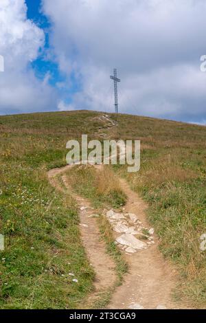 Col du Grand Colombier. Vue sur la Croix du Grand Colombier, la forêt, la route, et la crête des montagnes derrière Banque D'Images