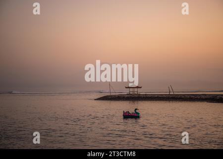 Paysage matinal pris sur la plage de sable. Vue sur la mer jusqu'au volcan Mont Agung. Panorama du lever du soleil sur la plage de sable de Sanur Banque D'Images