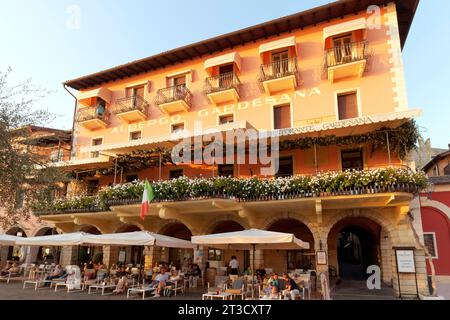 Hôtel traditionnel Gardesana avec terrasse restaurant, bâtiment historique, lumière du soir, Piazza Calderini, Torri del Benaco, rive est du lac de Garde Banque D'Images