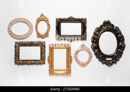 Cadres vintage vierges accrochés sur le mur blanc Banque D'Images