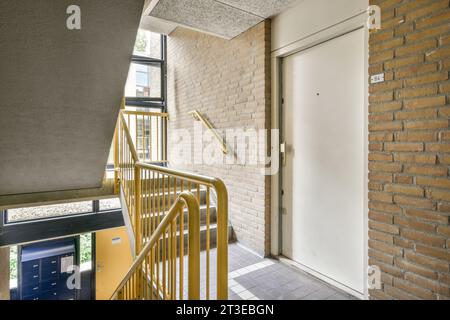 l'extérieur d'un bâtiment avec des escaliers menant à une porte ouverte qui mène à un petit balcon et patio Banque D'Images