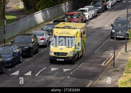 Une ambulance du NHS sur un appel d'urgence ralentit pour une bosse de vitesse en conduisant dans une rue résidentielle à Lambeth, au sud de Londres, le 20 octobre 2023, à Londres, en Angleterre. Banque D'Images