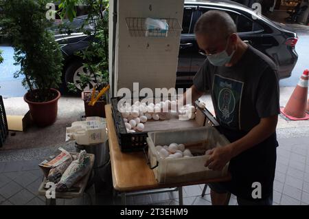 *** STRICTEMENT AUCUNE VENTE AUX MÉDIAS OU ÉDITEURS FRANÇAIS - DROITS RÉSERVÉS ***06 octobre 2023 - Taipei, Taiwan : un cuisinier taïwanais sort des œufs devant son restaurant. Taïwan a été frappé par un scandale concernant les mauvais œufs importés. La question a été fortement politisée, avec des sources pro-gouvernementales accusant la Chine d'enflammer le débat avec une campagne de fausses nouvelles. Banque D'Images