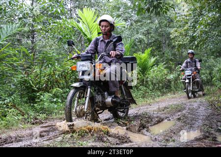 (231025) -- HAIKOU, 25 octobre 2023 (Xinhua) -- Li Wenyong (à gauche) et son collègue patrouillent dans la zone de Bawangling du parc national de la forêt tropicale humide de Hainan, dans la province de Hainan, dans le sud de la Chine, le 18 octobre 2023. Li Wenyong est un garde forestier du parc national de la forêt tropicale de Hainan dans la province insulaire du sud de la Chine. Il vit dans le village de Miao, dans le canton de Qingsong, qui est sous la juridiction du comté autonome de Baisha Li, et le village le plus proche de la zone de Bawangling du parc. C'est le cœur du pays du gibbon de Hainan. Les singes à crête noire ne peuvent être trouvés qu'à Hainan, et comme ils mettent rarement les pieds Banque D'Images