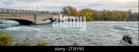 Vue panoramique Goat Island Bridge dans Niagara Falls State Park, en amont de la cascade Niagara Falls avec de belles feuilles d'automne feuillage coucher de soleil, fl rapide Banque D'Images