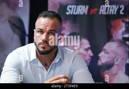 Ludwigsburg, Allemagne. 25 octobre 2023. Sükrü Altay, boxeur dans la division poids lourds légers, est assis sur le podium lors d'une conférence de presse pour un match de boxe entre lui et F. Sturm au MHP Arena de Ludwigsburg. Le combat aura lieu à la MHP Arena le 2 décembre 2023. Crédit : Bernd Weißbrod/dpa/Alamy Live News Banque D'Images
