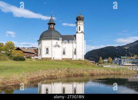 19.10.2023/Seefeld in Tirol, Österreich/Bild : Seekirche Heiliges Kreuz, Seekirchl, Heiligkreuzkirche/vorne : Raabach, kleiner Bach/re. : Kongresszentrum Seefeld, Olympia Kongress, Olympiakongresszentrum, Olympia Sport- und Kongresszentrum, Olympiabad Segressund/im: Skigebiet Rosshütte im Herbst *** 19 10 2023 Seefeld in Tirol, Autriche photo lac église Heiliges Kreuz, Seekirchl, Heiligkreuzkirche en face Raabach, petit ruisseau RE centre de congrès Seefeld, Olympia congrès, Olympia congrès, Olympia sport et centre de congrès, Olympiabad Seefeld en arrière-plan re ski A. Banque D'Images