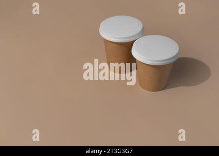 gobelets en papier avec couvercle recyclable sur fond beige Banque D'Images