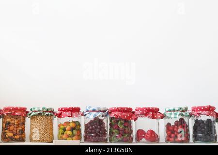 stockage des légumes alimentaires, des fruits et des céréales dans des bocaux en verre, fond blanc, espace de copie Banque D'Images
