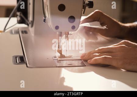 Human Hands Fashion Designer travaillant sur la machine à coudre gros plan travaillant dans Design Studio concept de l'industrie textile Banque D'Images