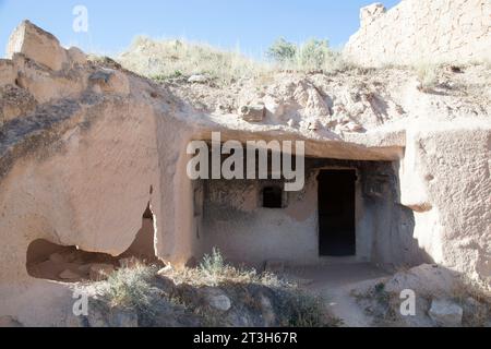 La vue de la petite maison résidentielle traditionnelle sculptée à l'intérieur de la roche tendre dans le village Cavusin, région de Cappadoce (Turquie). Banque D'Images