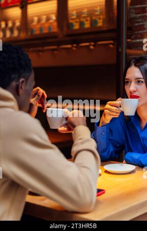 couple buvant du café heureux bavarder dans le café. Banque D'Images