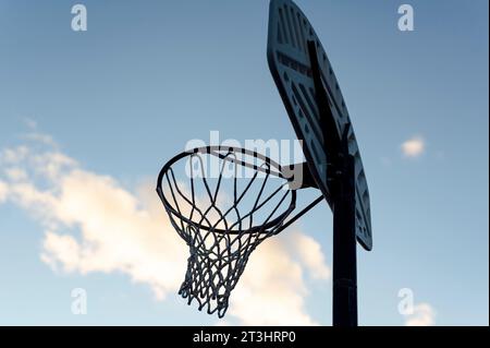 Basket-ball Hoop avec ciel bleu en arrière-plan, crépuscule Banque D'Images