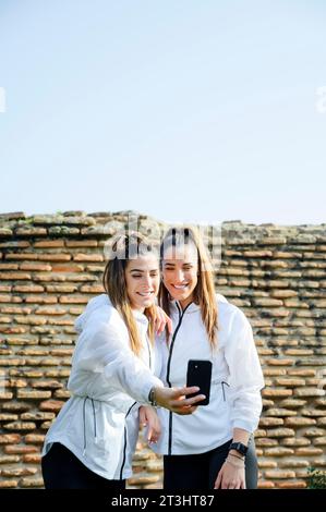 filles sportives souriantes prenant un selfie Banque D'Images