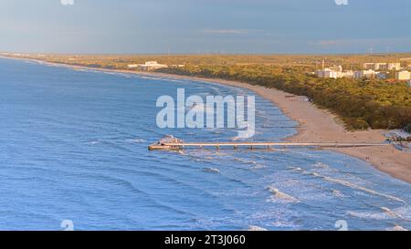 Prélassez-vous dans la sérénité baignée de soleil de la jetée de Kołobrzeg, telle que capturée par cette photo de drone. La vaste promenade en bois s'étend dans la Baltique azur. Banque D'Images