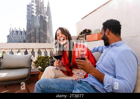 Multiracial beau couple heureux d'amoureux datant sur le balcon sur le toit à la Sagrada Familia, Barcelone - personnes multiethniques ayant un apéritif romantique sur Banque D'Images