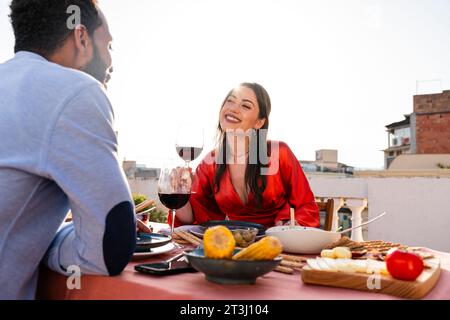 Multiracial beau couple heureux d'amoureux datant sur le balcon sur le toit à la Sagrada Familia, Barcelone - personnes multiethniques ayant apéritif romantique din Banque D'Images