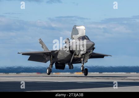 Patuxent River, États-Unis. 24 octobre 2023. Un avion de chasse furtif F-35B Lightning II du corps des Marines effectue un atterrissage vertical roulant embarqué sur le pont d'envol du porte-avions HMS Prince of Wales de classe Queen Elizabeth de la Royal Navy lors d'essais en vol de phase 3 de développement, le 24 octobre 2023 au large des côtes du Maryland, aux États-Unis. Crédit : Kyra Helwick/États-Unis Navy photo/Alamy Live News Banque D'Images