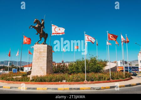 Les drapeaux de Türkiye et de Chypre du Nord flottent à côté d'une statue de Atatürk à cheval à un rond-point de la circulation dans le nord de Nicosie Banque D'Images