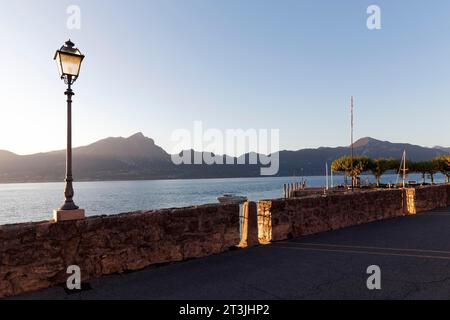 Promenade au bord du lac, soleil du soir, Torri del Benaco, rive orientale du lac de Garde, Vénétie, province de Vérone, Italie Banque D'Images