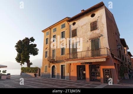 Maisons sur la promenade du lac dans la lumière du soir, vieille ville historique, Torri del Benaco, lac de Garde rive est, province de Vérone, Italie Banque D'Images